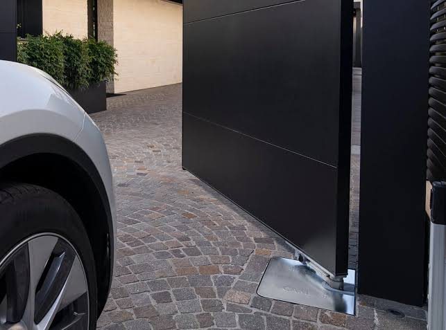 CAME automated gate on a cobbled driveway at dusk