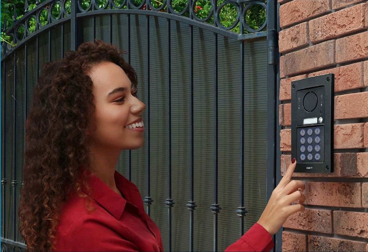 Visitor using a CAME video intercom keypad at an entrance